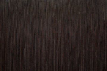 Vertical natural texture of dark brown wood veneer.
