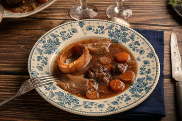 Well-cooked beef shank in wine sauce served in an antique plate