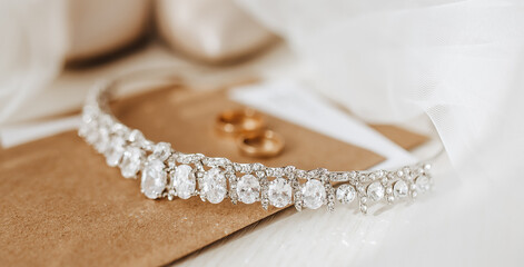 Wedding details. Diadem with diamonds, rings of the bride and groom, veil, shoes, invitation, letter from kravt paper. Macro shots. Morning fees girl.