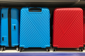 close up image of two big suitcases red and blue on shelf. Waiting for journey. Traveling  concept.