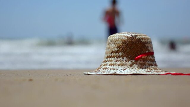 Women's hat lies on the sand.