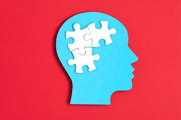 Papercut head with jigsaw puzzle pieces inside. Mental health problems, psychology, memory, logic, thinking process, solution, mental illness
