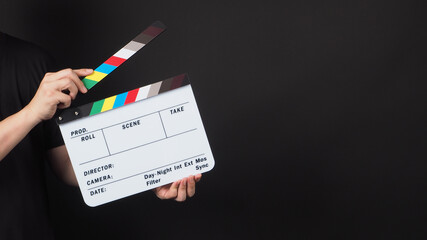 Hand is holding movie slate.It is used in video production and film industry on black background.