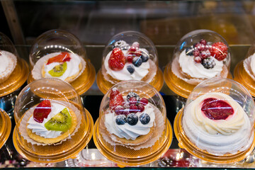A variety of desserts cakes with berries ready to eat in the shop window