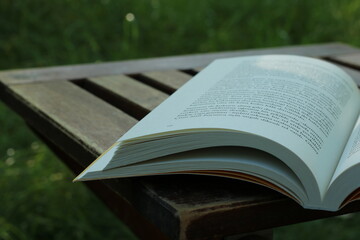 Das Buch steht auf einem hölzernen Couchtisch und grünes Gras schaut nach hinten