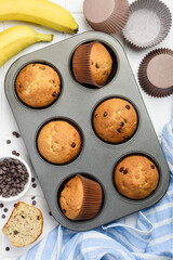 Chocolate banana cupcake muffins in a metal baking dish on a white background. Top view