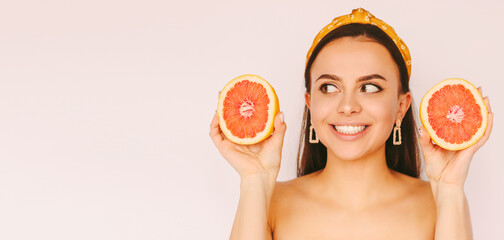 Portrait cheerful beautiful woman posing with grapefruit slices in hands isolated on white background. Young happy girl have fun, hold healthy citrus fruits in hands. Copy space, beauty, fashion, diet