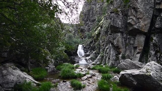 Small and beautiful waterfall in the middle of a very rocky area with lots of nature around in a natural park 
