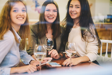 Three female friends enjoying meeting in cozy cafe