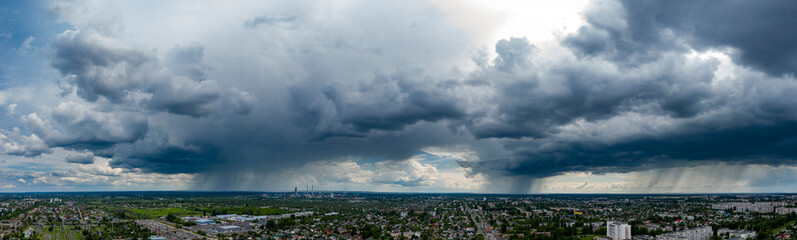 Panoramic view dramatic sky over city. Far village sight under cloudy sky. Aerial Flying over town,...