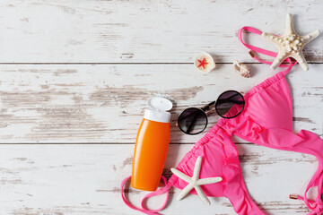 Summer background with fashion woman swimsuit bra and beach accessories top view.