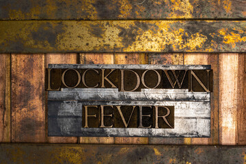 Photo of real authentic typeset letters forming Lockdown Fever text on vintage textured silver...