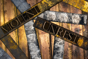 Photo of real authentic typeset letters forming Violent Unrest text on vintage textured silver...