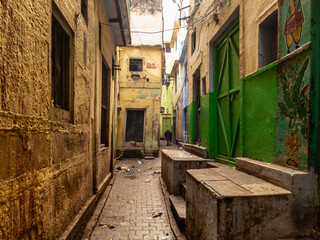 Fototapeta na wymiar A narrow alley with faded architecture in the old city of Varanasi