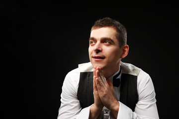 Portrait of a young and handsome man with emotion and funny face in black bow-tie isolated on black background.with copy space. 