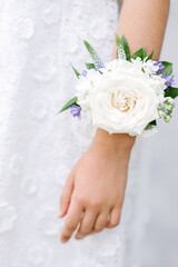 A woman's hand with a bracelet of fresh flowers. Light and lilac spring color. Wedding day. Bouquet with love