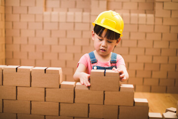 toddler girl pretend play builder role by using cardboard blocks