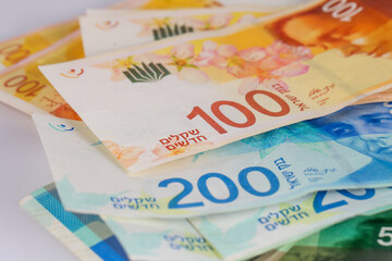 Lots of 50, 100 and 200 Israeli Shekels (NIS) bank note isolated on white background.