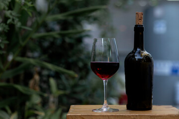 Glass of red wine with a bottle.
