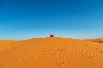 Fototapeta na wymiar Loving couple in the Sahara desert. Joint rest.