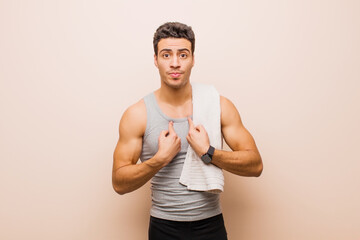 young arabian man pointing to self with a confused and quizzical look, shocked and surprised to be...