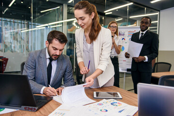 Close up handsome businessman signing partnership agreement concept. Focused male on putting...