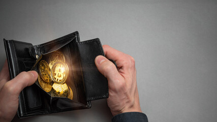 Cryptocurrency coin bitcoin in a black wallet. Bitcoin accumulation, trading sell and buy concept. Cryptocurrency saving symbol.
