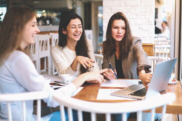 Modern three female colleagues brainstorming about work