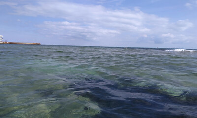 Море штормит на берегу песчаного пляжа Феодосии у эллинов на черноморской набережной 