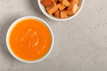 Pumpkin and carrot soup with fresh dill on table