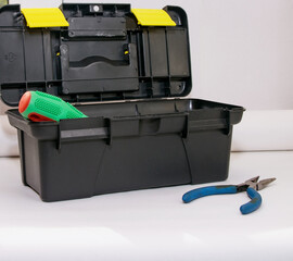 Screwdrivers are in the gray open tool box, next to the pliers