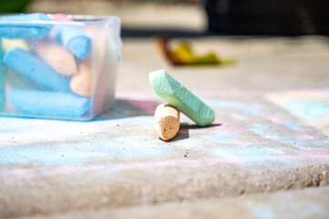 Ground level shot with selective focus on piece of sidewalk chalk