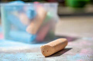 Ground level shot with selective focus on piece of sidewalk chalk
