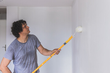 Multi ethnic young man painting the room