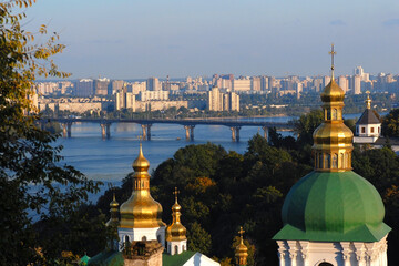 Fototapeta na wymiar Church with green-gold doom in Ukraine where river streams