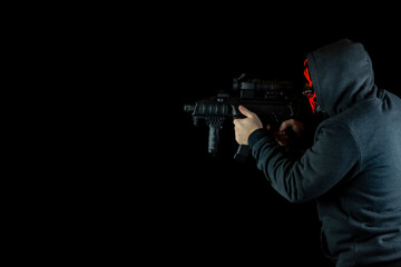Man in scary mask with machine gun. Steampunk theme photo with black background.