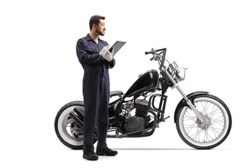 Motorbike mechanic writing a document and looking at a chopper