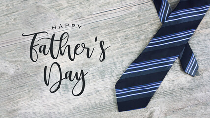 Fototapeta na wymiar Happy Father's Day Greeting Card Calligraphy Text with Striped Neck Tie Over Light Wood Background