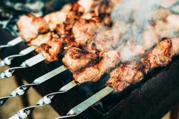  Browned toasted skewers pork meat on a charcoal grill.