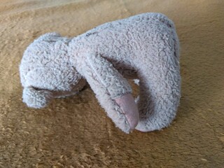 Fototapeta na wymiar small beige teddy bear lying on a blanket
