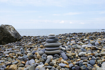 Pyramid of round stones on the seashore, the concept of harmony, balance and meditation.