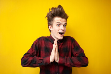 pleasantly surprised guy on a yellow isolated background, the man is touched and admires