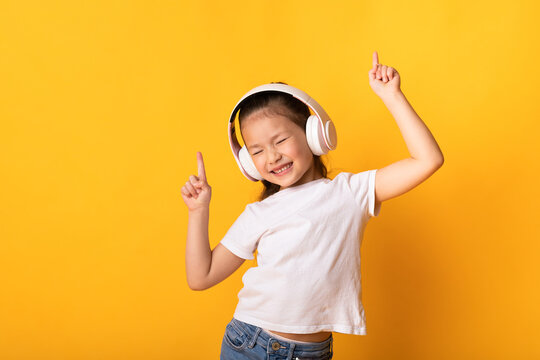 Smiling Asian Girl Enjoying Music With Headphones