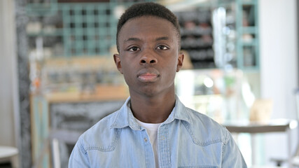 Obraz premium Portrait of Serious Young African Man Looking at Camera