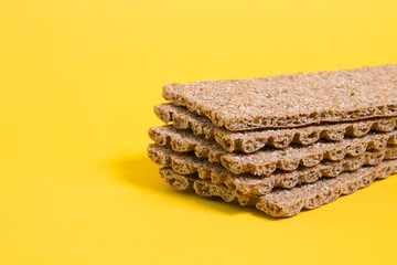 rye bread crisps on a yellow background copy space