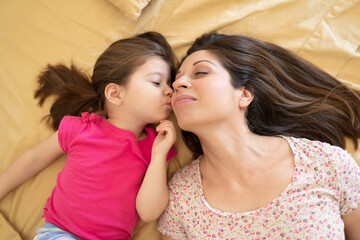 Cute little girl kissing her mom