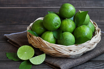 Natural fresh lime in basket on wooden background.