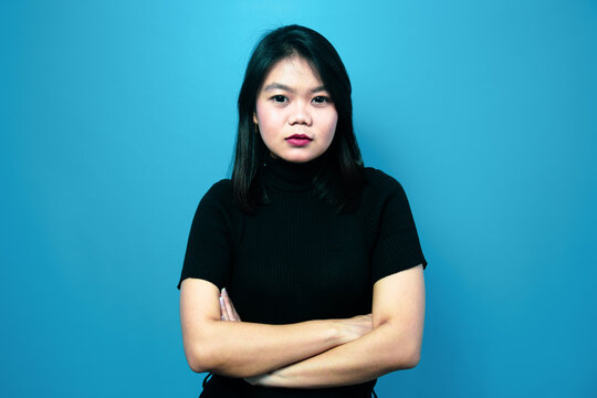 Portrait of Young beautiful asian women wearing black turtle neck shirt with blue isolated background