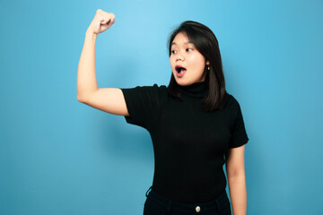 Portrait of Young beautiful asian women wearing black turtle neck shirt with blue isolated background