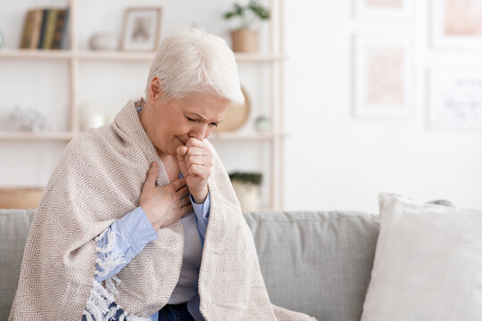 Sick Senior Woman Covered In Blanket Coughing Hard At Home